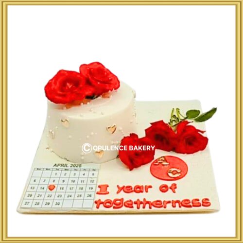 Custom calendar theme anniversary cake in Lahore featuring red roses and custom date plaque by Opulence Bakery.
