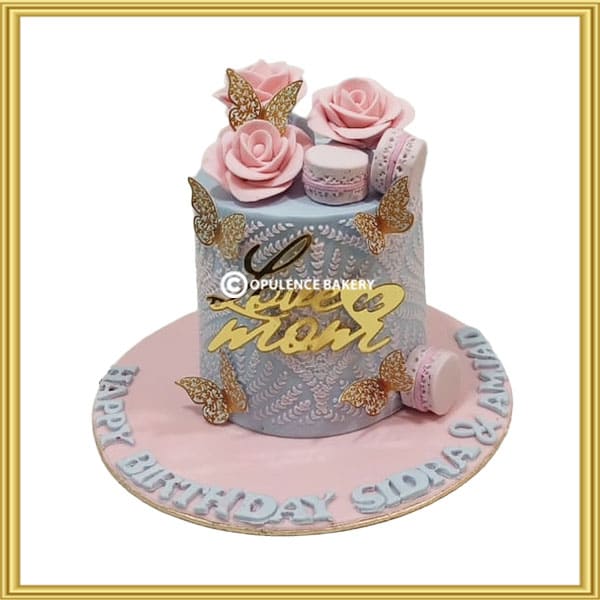 Customized mother's birthday cake with pink roses and gold butterflies in Lahore by Opulence Bakery.