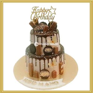Customized 2 tier chocolate drip cake in Lahore loaded with KitKats, Oreos, and gold butterflies by Opulence Bakery.