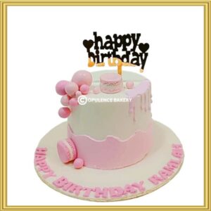 Pink birthday cake with macarons and bubble spheres in Lahore by Opulence Bakery.