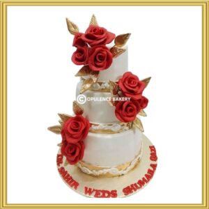 Custom 3 tier floral wedding cake in Lahore with red sugar roses and gold leaves by Opulence Bakery.