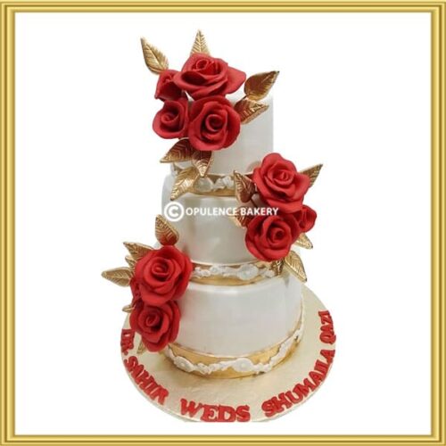 Custom 3 tier floral wedding cake in Lahore with red sugar roses and gold leaves by Opulence Bakery.